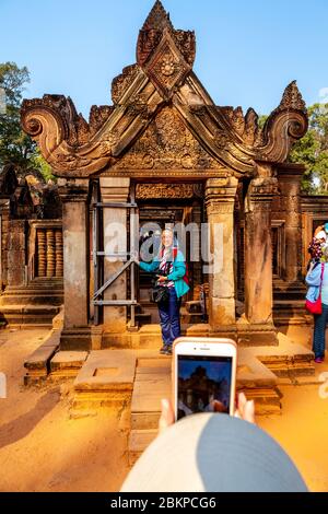 I visitatori che hanno scattato fotografie al tempio di Banteay Srey, al complesso del tempio di Angkor Wat, a Siem Reap, Cambogia. Foto Stock