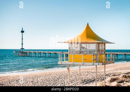 Brighton Surf LIFE Saving Tower con persone che camminano lungo il molo sullo sfondo, South Australia Foto Stock