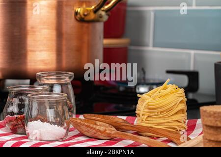 Spaghetti secchi su un bancone da cucina con utensili da cucina Foto Stock
