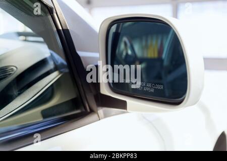 Specchietto retrovisore laterale con una scritta che avvisa che gli oggetti sono più vicini dei cadetti Foto Stock