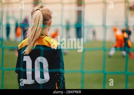 Ragazza di calcio che gioca come goalie. Squadra di calcio femminile giovane che gioca partita torneo Foto Stock