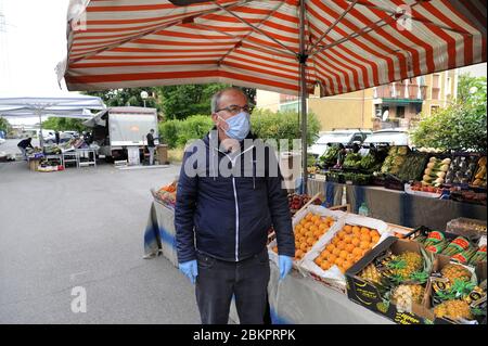 Epidemia di coronavirus, alleggerimento delle misure di sicurezza fase 2; riapertura sperimentale di un mercato all'aperto nel comune di Corsico, periferia sud di Milano (Italia); maschere, ingresso limitato, percorsi obbligatori, stalle distanziate, controllo della temperatura corporea e distanza sociale. Foto Stock