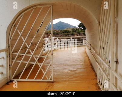 Porta d'ingresso alle grotte di Nerja da Maro, Axarquia, Cost del Sol, Spagna. Le grotte di Nerja si trovano vicino a Maro, scoperte solo nel 1959, quando cinque ragazzi che cacciano i pipistrelli dietro Maro scoprirono grotte sconosciute e antichi dipinti rupestri. Questo passaggio a spirale e un ponte si uniscono a Maro per l'attrazione per i visitatori. Maro celebra la festa della castagna ogni Halloween. Foto Stock