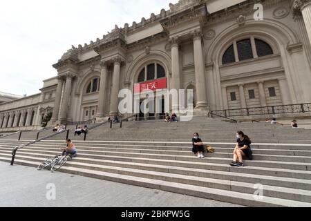 Persone sociali che si distendono in maschere facciali sulle scale del Metropolitan Museum of Art, in un fine settimana durante il coronavirus o covid-19 pandemic Foto Stock