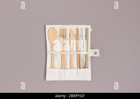 Set di posate di bambù in una custodia su sfondo grigio. Concetto di zero sprechi. Foto Stock
