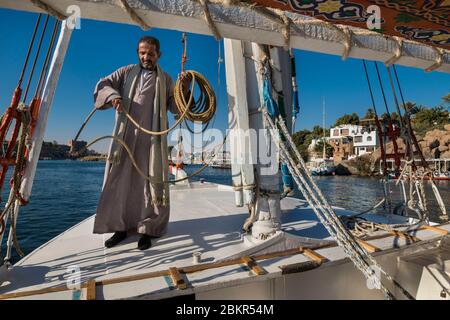 Egitto, Alto Egitto, vicino all'isola di Elefanina, marinaio su una feluca che naviga sul Nilo Foto Stock