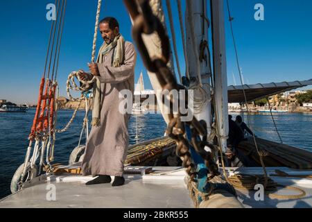 Egitto, Alto Egitto, vicino all'isola di Elefanina, marinaio su una feluca che naviga sul Nilo Foto Stock