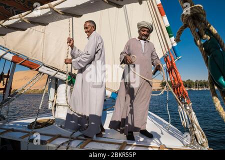 Egitto, Alto Egitto, vicino all'isola di Elefanina, marinaio su una feluca che naviga sul Nilo Foto Stock