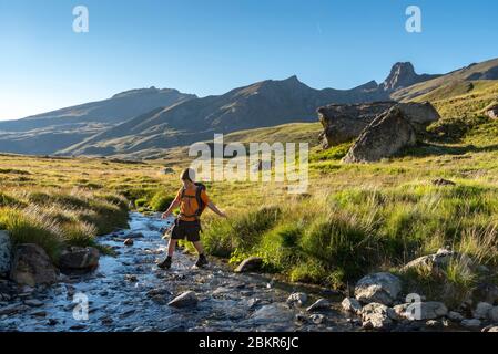Francia, Hautes-Alpes (05), Parco Naturale Regionale di Queyras, Saint-V?ran, Lac de la Blanche (2499m), giovane escursionista che attraversa un torrente (MR) Foto Stock