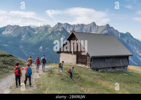 Francia, Hautes-Alpes (05), Parco Naturale Regionale di Queyras, Arvieux, escursionisti passando per gli chalet della zona di Queyron Foto Stock
