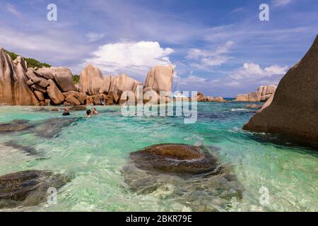 Seychelles, isola di Digue, Anse Marron, barca a vela Moorings 4800 all'ancora, rocce granite intorno alla spiaggia, nuoto Foto Stock