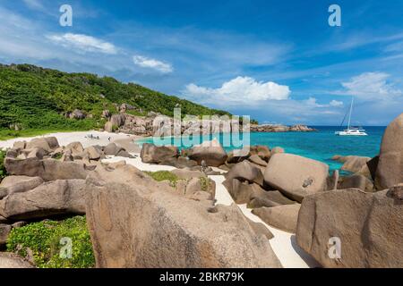 Seychelles, isola di Digue, Anse Marron, barca a vela Moorings 4800 all'ancora, rocce granite intorno alla spiaggia Foto Stock