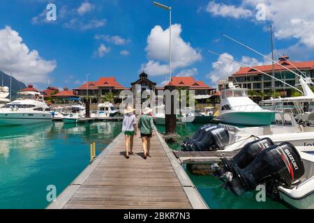 Seychelles, isola di Mahe, donne che camminano sul molo di Eden Plaza Marina Foto Stock