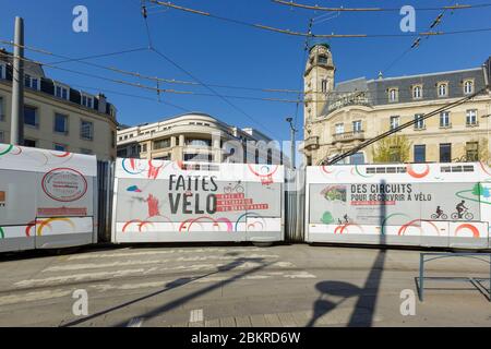 Francia, Meurthe et Moselle, Nancy, Covid 19 o Coronavirus lockdown, il tram, i trasporti pubblici nella zona della stazione di Nancy Ville la facciata di ex sede del giornale l'Est Republicain da parte dell'architetto Louis le Bourgeois da Ecole de Nancy (scuola di Nancy) Foto Stock