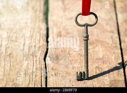 Vecchia chiave in piedi su un asse di legno - concetto di soluzione Foto Stock