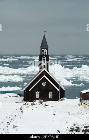 Chiesa di Sion coperta di neve in Ilulissat Groenlandia con la Baia di disco sullo sfondo Foto Stock