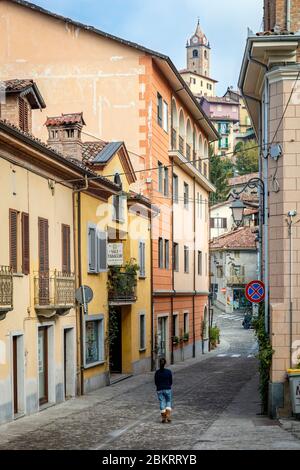 Donna cammina lungo la strada acciottolata a Monforte d'Alba, Piemonte, Italia Foto Stock