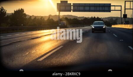 Automobili su una autostrada al tramonto (SHALLOW DOF; dai toni di colore immagine) Foto Stock