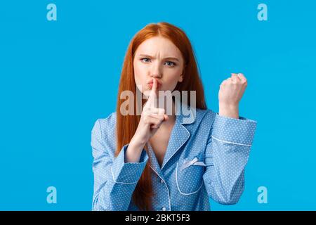 Shut up o altro. Arrabbiato e dispiaciuto redhead girl minacciano compagno di stanza di essere tranquillo e il pugno di scuotimento, avvertimento comportarsi bene, non dite a nessuno segreto, fare Foto Stock