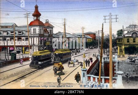 [ 1900 Giappone - Ponte Shinbashi Ginza ] - UN tram attraversa il ponte Shinbashi (anche Shimbashi) mentre un altro entra nel viale Ginza di Tokyo. L'edificio con la torre dell'orologio è il Teikoku Hakuhin-kan Kankoba (帝国博品館勧工場, attuale Hakuhinkan). Fondata nell'ottobre 1899 (Meiji 32), era un grande magazzino prototipo. cartolina vintage del xx secolo. Foto Stock