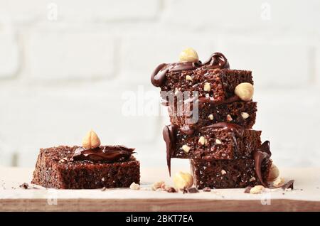 Pila di pezzi di brownie con nocciola su un tavolo grigio con sfondo grigio. Foto Stock
