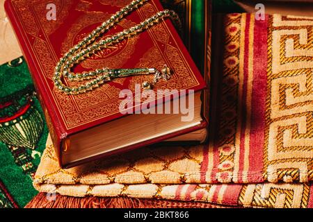 Holly Quran e perline di preghiera sul tappeto di preghiera da vicino in Ramadan Kareem Foto Stock