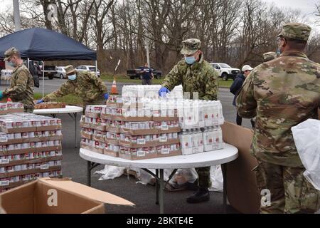 I soldati della Guardia Nazionale di New York assistono nella distribuzione di cibo in risposta al COVID-19, pandemia di coronavirus al Veterans Field Park 24 aprile 2020 ad Amsterdam, New York. Foto Stock