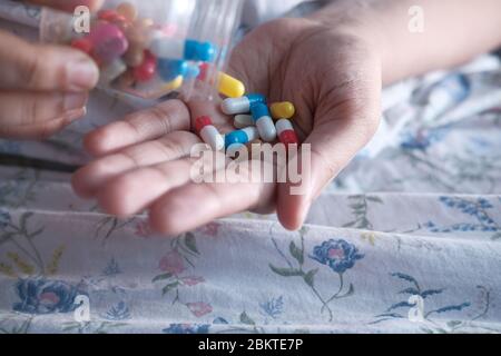 donna che versa pillole da bottiglia a portata di mano Foto Stock