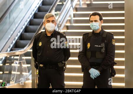 Polizia spagnola con maschere protettive che sorvegliano una stazione della metropolitana a causa di Coronavirus. Foto Stock