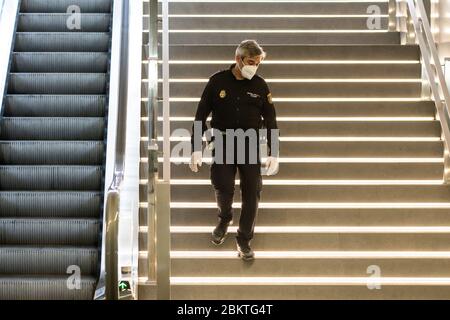 Polizia spagnola con maschere protettive che sorvegliano una stazione della metropolitana a causa di Coronavirus. Foto Stock