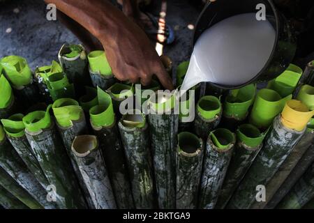 Lhokseumawe, Aceh, Indonesia. 5 maggio 2020. Lavoratori che mettono riso glutinoso e alcune altre spezie, in bambù per fare lemang durante Ramadan.Lemang è uno dei cibi popolari in Aceh, come un menu iftar nel mese santo di Ramadhan, dove i musulmani in tutto il mondo digiunano dall'alba al tramonto per un mese intero. Credit: Maskur has/SOPA Images/ZUMA Wire/Alamy Live News Foto Stock