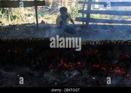 Lhokseumawe, Aceh, Indonesia. 5 maggio 2020. Burning lemang bambù durante Ramadan.Lemang è uno dei cibi popolari in Aceh, come un menu iftar nel mese santo di Ramadhan, dove i musulmani in tutto il mondo veloce dall'alba al tramonto per un mese intero. Credit: Maskur has/SOPA Images/ZUMA Wire/Alamy Live News Foto Stock