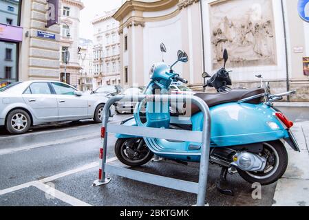 scooter blu ciclomotore parcheggiato sul lato strada della città Foto Stock