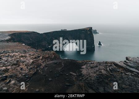 Una famosa roccia chiamata Dyrholaey si trova in Islanda vicino alla città di Vik. Questa roccia è un bersaglio molto popolare per i fotografi in qualsiasi condizione meteorologica Foto Stock