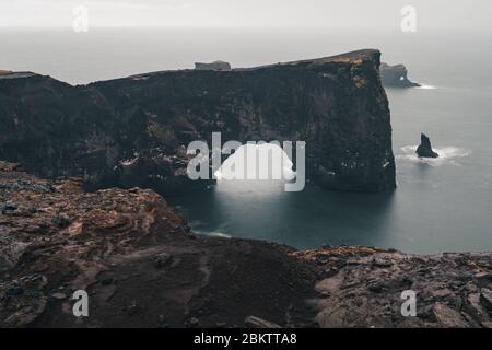 Una famosa roccia chiamata Dyrholaey si trova in Islanda vicino alla città di Vik. Questa roccia è un bersaglio molto popolare per i fotografi in qualsiasi condizione meteorologica Foto Stock