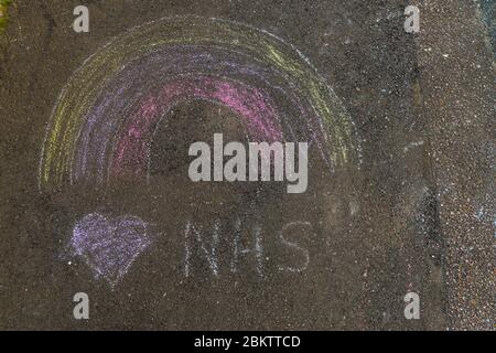 Un quadro di un arcobaleno disegnato in gesso sul marciapiede durante la crisi del covid-19 Foto Stock