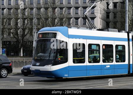 Tram bianco e blu in movimento nel centro di Zürich, Svizzera, marzo 2020. I tram sono una forma di trasporto pubblico in molte grandi città della Svizzera. Foto Stock