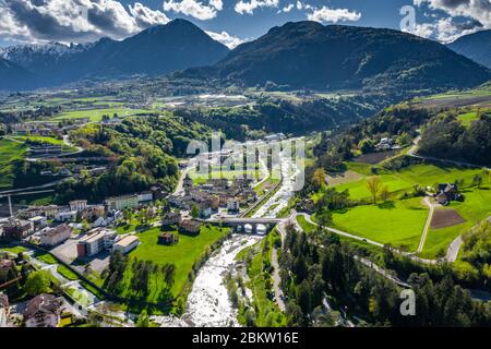 Veduta aerea della valle Cares, Trentino, verdi pendici delle montagne d'Italia, enormi nuvole su una valle, tetti di case, Dolomiti sullo sfondo Foto Stock