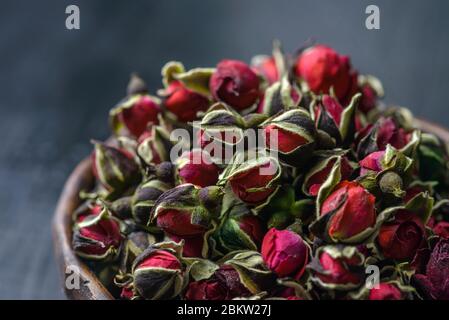 Rosa di tè essiccata, boccioli di rosa dessert in una tazza di ceramica. Messa a fuoco selettiva. Stile vintage. Tè cinese rosa. Germoglio di rosa essiccato, che sono usati per fare il tè. Foto Stock