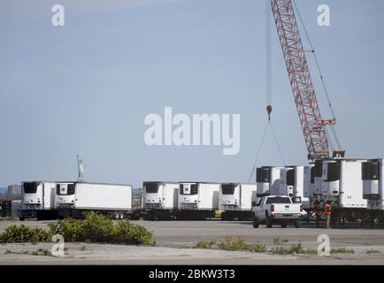 Brooklyn, Stati Uniti. 05 maggio 2020. La Statua della libertà si trova dietro i camion frigoriferi che sono utilizzati come parte di un morgue temporaneo per le vittime di Coronavirus a New York City il martedì 5 maggio 2020. La pandemia del coronavirus COVID-19 colpisce 212 paesi in tutto il mondo, che rappresentano oltre 250,000 decessi. Foto di John Angelillo/UPI Credit: UPI/Alamy Live News Foto Stock