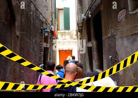 Turisti che camminano per le strade italiane. Nastro barriera - quarantena, isolamento, divieto di ingresso. Concetto di Covid-19. Foto Stock