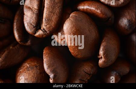 Caffè arrosto in grani sfondo a cornice. Macromatura di chicchi di caffè con consistenza visibile. Foto Stock