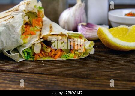 Shawarma fatto in casa, burrito, involtino di pollo con verdure e salsa. Ingredienti per la vista frontale, primo piano Foto Stock