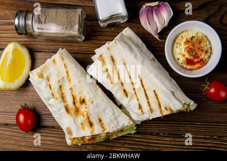 Shawarma fatto in casa, burrito, involtino di pollo con verdure e salsa. Vista dall'alto ingredienti, primo piano Foto Stock