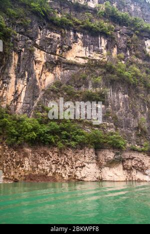 Wuchan, Cina - 7 maggio 2010: Dawu o Misty Gorge sul fiume Daning. Il percorso è stato arroccato in una scogliera marrone-nera con un po' di verde sopra la grana smeraldo Foto Stock