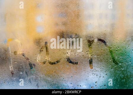 Pioggia di parola scritta su cristalli bagnati con la nebbia in una piovosa giornata d'inverno. Foto Stock