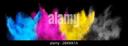 Colore CMYK ciano magenta giallo chiave holi vernice colore polvere esplosione isolato su sfondo nero scuro. Stampa industria di produzione Foto Stock