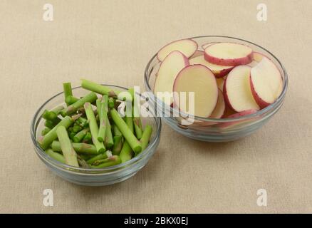 Ingredienti vegetali preparati per la cottura di asparagi freschi crudi tritati e patate novelle rosse a fette Foto Stock