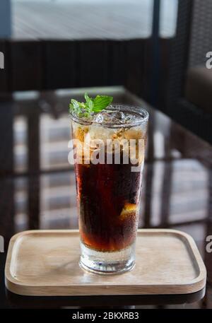 Cocktail drink Long Island con decorazioni a base di piante su sfondo nero. Foto Stock