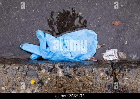 Brooklyn, NY - 23 marzo 2020. I guanti chirurgici scartati sono una vista familiare nelle strade e sui marciapiedi. Foto Stock